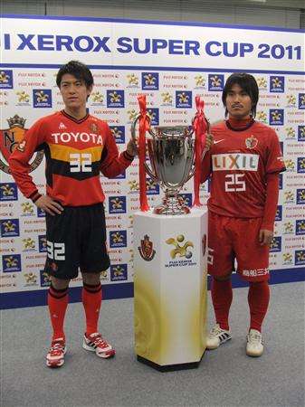 ياسوشي إيندو ( يمين ) وهايوما تاناكا يقفان بجانب الكأس